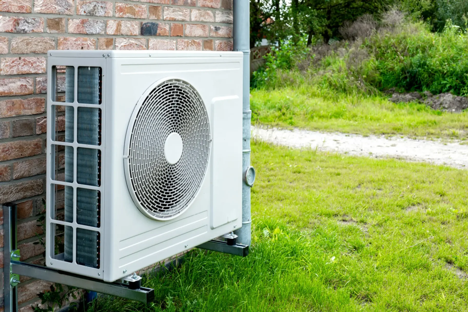 Outdoor air conditioning unit mounted on brick