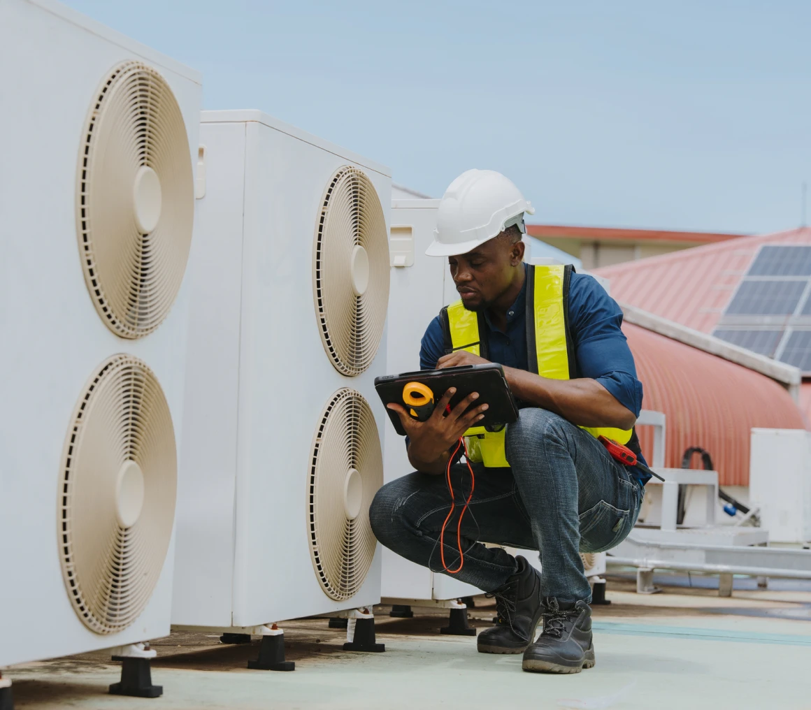 Engineer assessing industrial cooling equipment outdoors