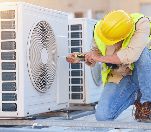 Technician repairing outdoor AC unit