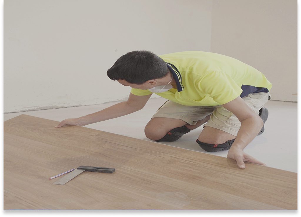 Person laying down wood-style floorboards